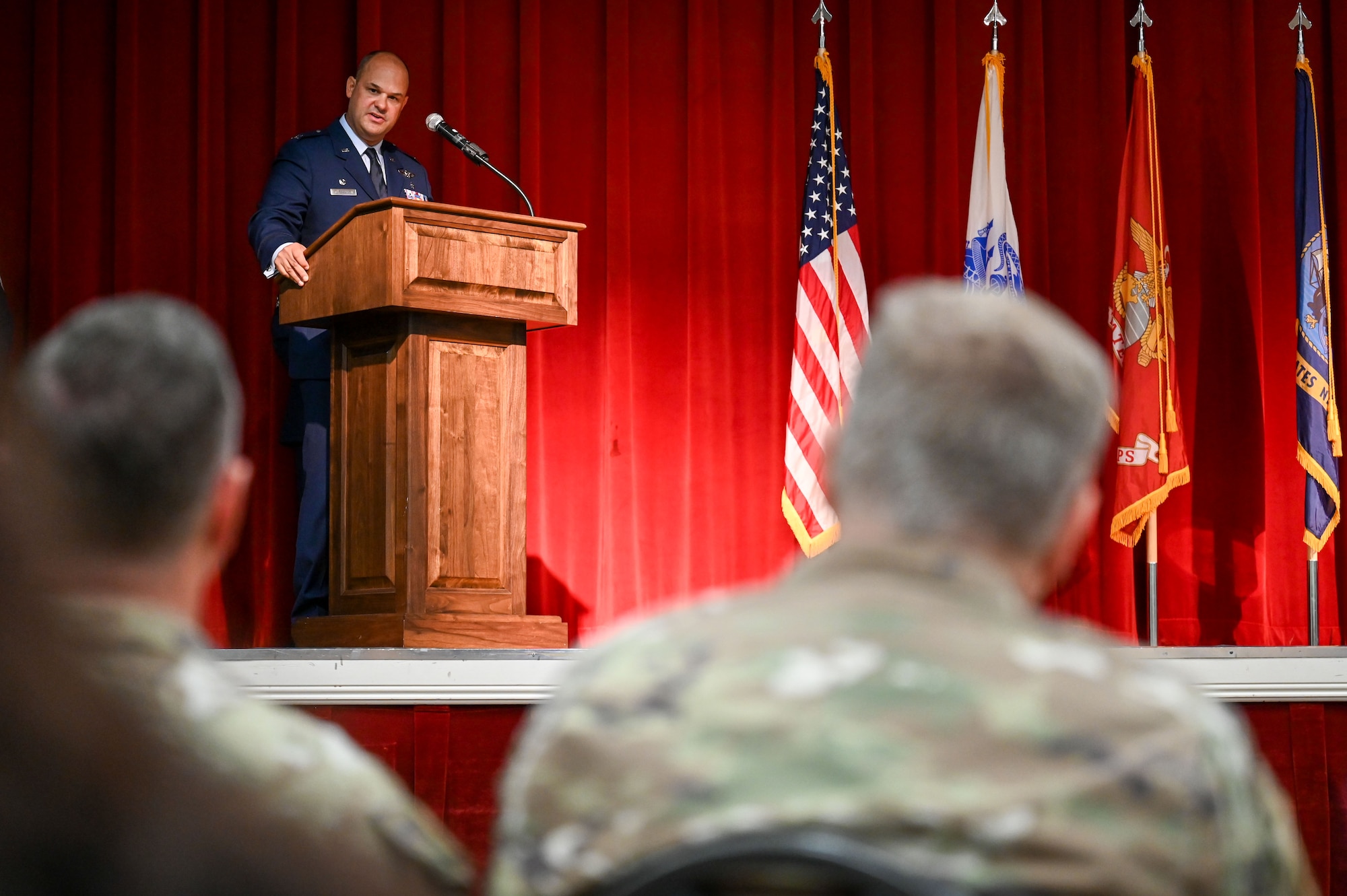 Man in uniform speaking at a podium on stage