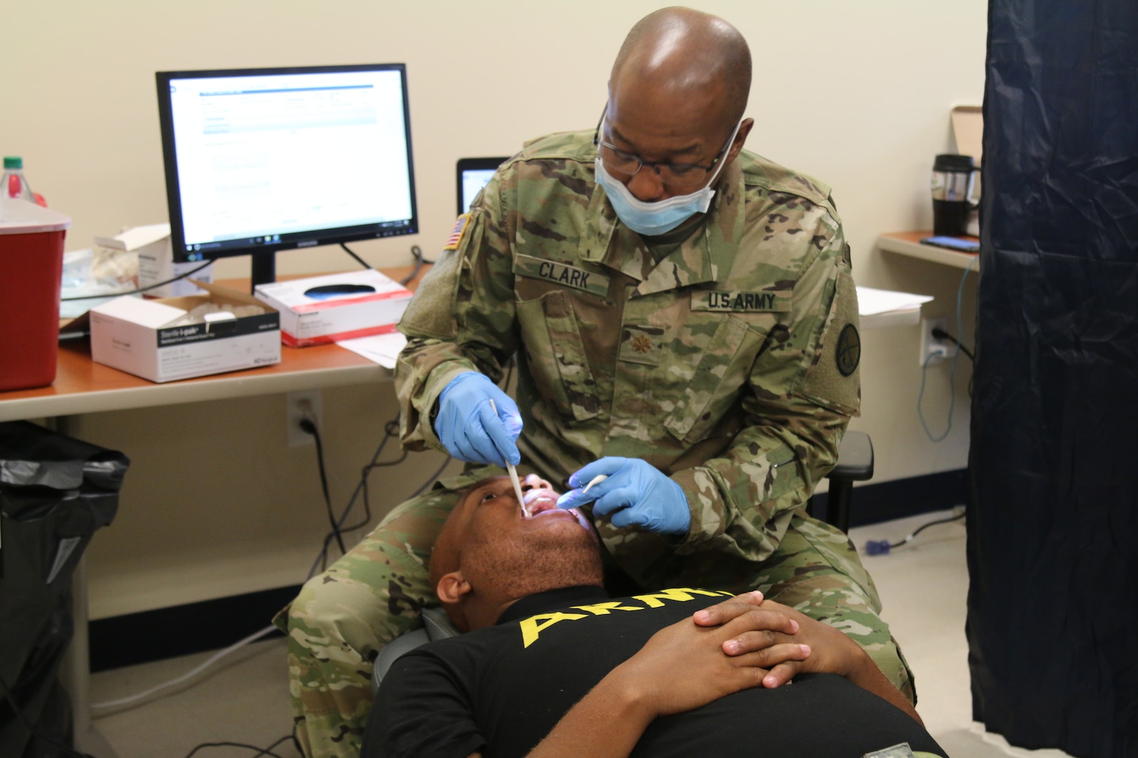 Dentist in military uniforms exams soldiers teeth