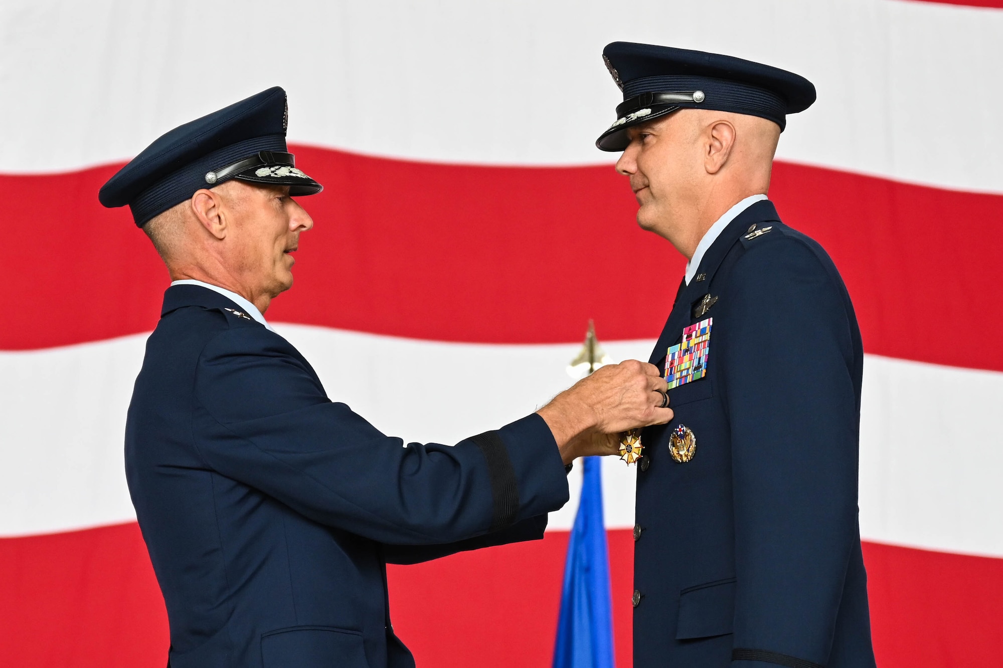 U.S. Air Force Maj. Gen. Gregory Kreuder, 19th Air Force commander, pins the Legion of Merit medal on Col. Jeff Marshall, outgoing 97th Air Mobility Wing (AMW) commander, during the wing change of command ceremony at Altus Air Force Base, Oklahoma, July 11, 2025. Marshall took command of the 97th AMW on July 14, 2023. (U.S. Air Force photo by Airman 1st Class Lauren Torres)