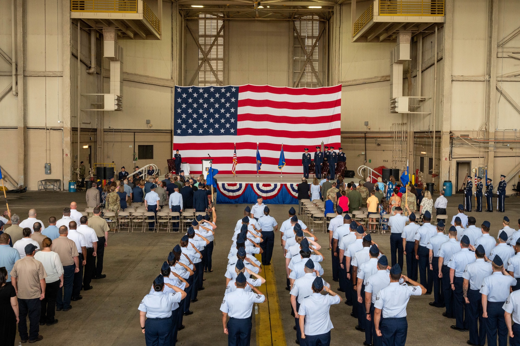 Airmen from the 97th Air Mobility Wing (AMW) salute the flag during the wing change of command ceremony at Altus Air Force Base, Oklahoma, July 11, 2025. During the ceremony, Col. Jeffrey Marshall relinquished command of the 97th AMW to Col. Richard Kind. (U.S. Air Force photo by Senior Airman Kari Degraffenreed)
