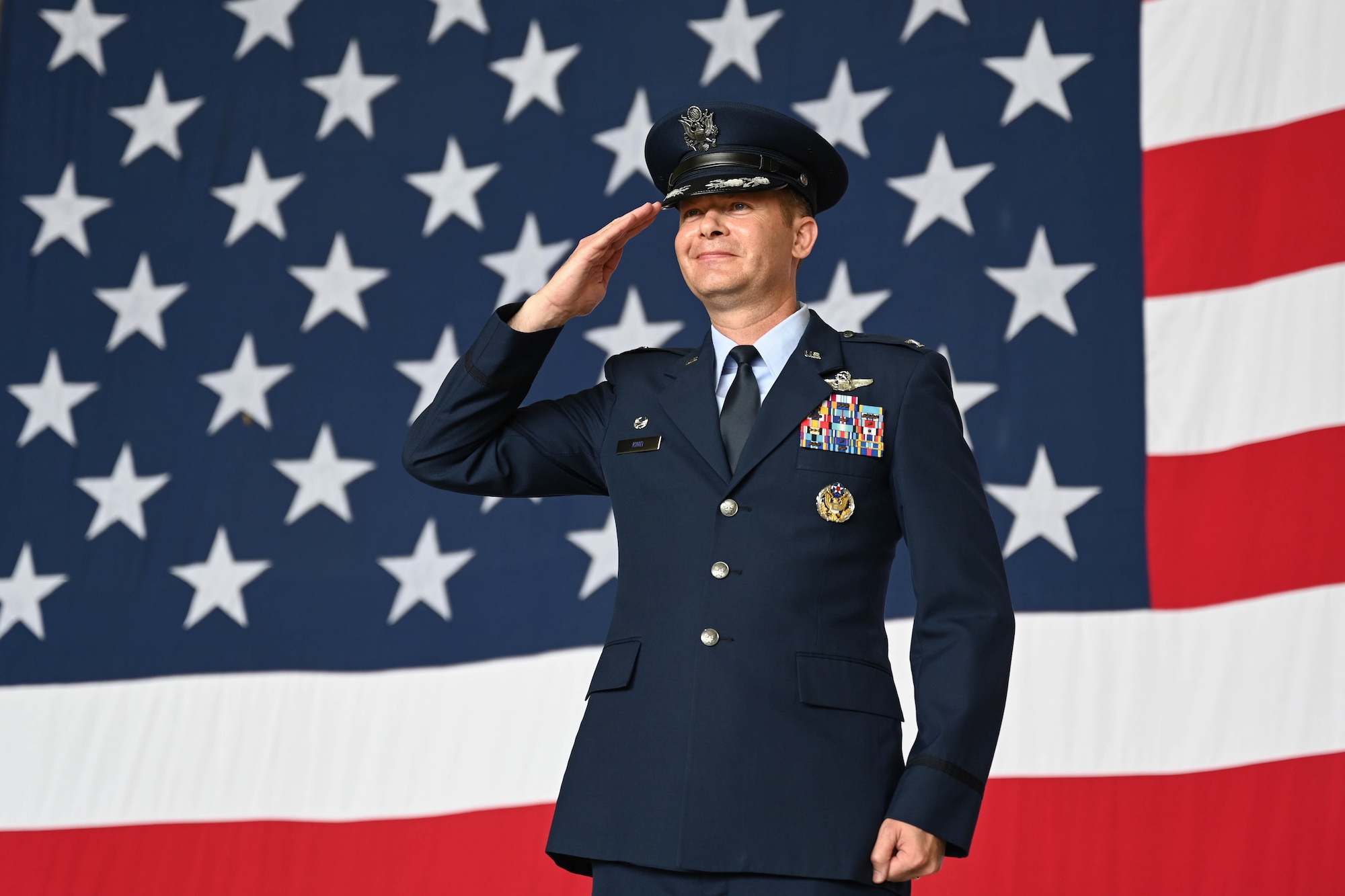 U.S. Air Force Col. Richard Kind, 97th Air Mobility Wing (AMW) commander, salutes Airmen from the Mighty 97th during the wing change of command ceremony at Altus Air Force Base, Oklahoma, July 11, 2025. Kind was appointed as the new commander of the 97th AMW during the ceremony. (U.S. Air Force photo by Airman 1st Class Lauren Torres)