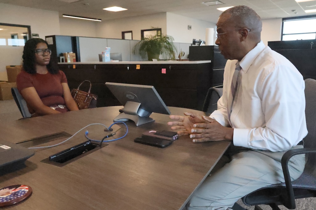 Man sitting at table talking to a woman.