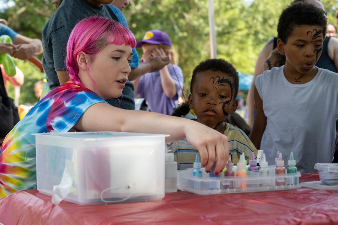 A volunteer paints a child's face. (U.S. Air Force photo by Airman 1st Class Thalia Bonte)