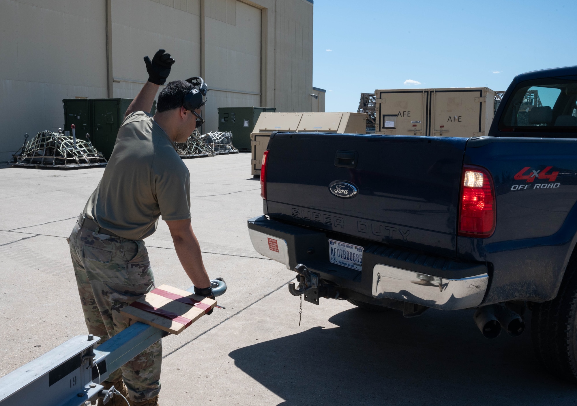 Senior Airman Jonathan Gonzalez-Rodriguez, 5th Logistics Readiness Squadron (5LRS)  air transportation specialist, guides a truck into place to attach a trailer at Minot Air Force Base, North Dakota, July 1, 2025. The 5LRS air transportation function at Minot AFB plays a critical role in ensuring mission success by loading and moving essential cargo to support global operations. (U.S. Air Force photo by Airman 1st Class Wesley Davies)