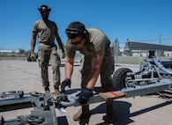 Senior Airman Jonathan Gonzalez-Rodriguez, 5th Logistics Readiness Squadron (5LRS)  air transportation specialist, attaches a trailer to a forklift to bring cargo to a C-5M Super Galaxy at Minot Air Force Base, North Dakota, July 1, 2025. The 5LRS air transportation function is vital to the mission at Minot AFB because it enables the timely delivery of equipment and supplies to missions in and outside of the base. (U.S. Air Force photo by Airman 1st Class Wesley Davies)