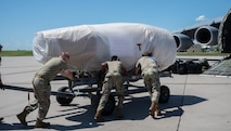 Airmen from the 5th Logistics Readiness Squadron (5LRS) help push a B-52H Stratofortress engine into place to be put onto a C-5M Super Galaxy at Minot Air Force Base, North Dakota, July 1, 2025. The 5LRS air transportation function at Minot AFB plays a critical role in ensuring mission success by loading and moving essential cargo to support global operations. (U.S. Air Force photo by Airman 1st Class Wesley Davies)