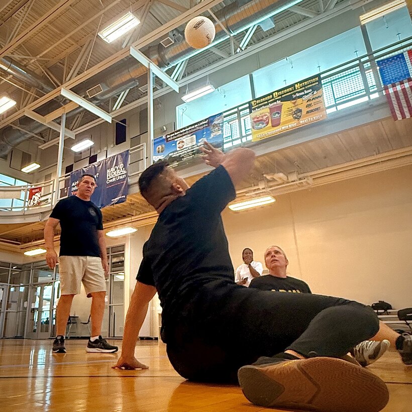 Sgt. 1st Class Alvarez moving under the ball, preparing to hit it back over.
