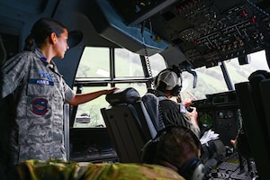 A girl looks out the window on a flight deck.