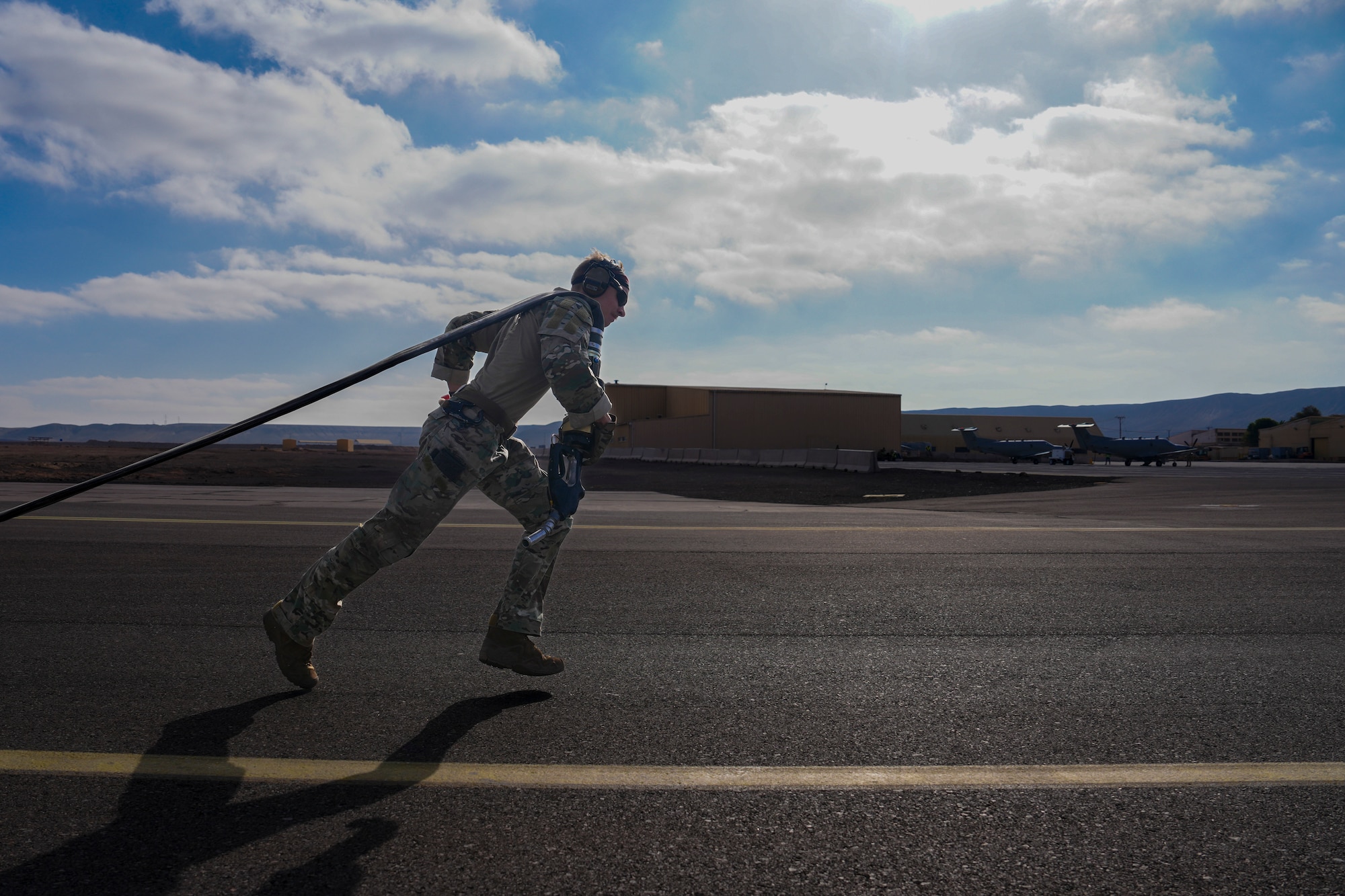 An Air Commando assigned to the 27th Special Operations Wing pulls a hose connected to an MC-130 Commando II for a forward arming and refueling point demonstration for Chilean Airmen at Antofagasta, Chile, May 29, 2025 as part of Southern Star 2025