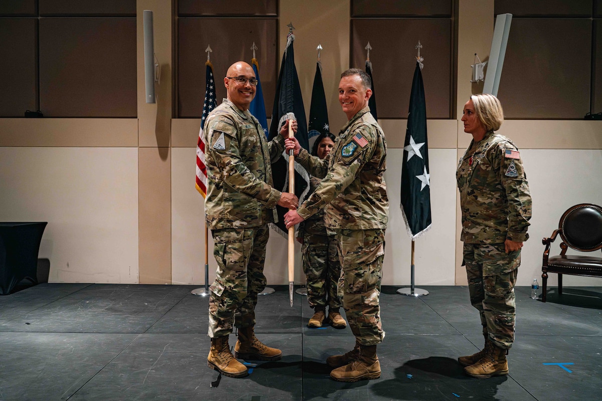 man passes guidon to man