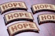 A close-up image of five HOPE Spiritual Fitness Initiative patches sitting on a table.