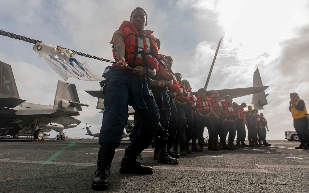 Sailors, assigned to deck department’s forward division, heave a phone-and-distance line on the flight deck of Nimitz-class aircraft carrier USS George Washington (CVN 73) during a fueling-at-sea evolution with Military Sealift Command chartered ship motor tanker Badlands Trader while underway in the Celebes Sea, July 10, 2025.