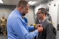 Ryan A. Busby, U.S. Army Financial Management Command deputy to the commander, presents Brett A. Dunn, USAFMCOM deputy chief of staff, with a Department of the Army Meritorious Civilian Service Medal at the Maj. Gen. Emmett J. Bean Federal Center in Indianapolis June 4, 2025. Before Dunn left USAFMCOM for a career in higher education, he was awarded the medal for his innovative and creative leadership in leading the command’s general staff through a time of significant change from November 2022 to June 2025. (U.S. Army photo by Brad Staggs)