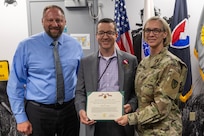 Ryan A. Busby, U.S. Army Financial Management Command deputy to the commander, left, and Col. Michelle M. Williams, USAFMCOM commander, present Brett A. Dunn, USAFMCOM deputy chief of staff, center, with a Department of the Army Meritorious Civilian Service Medal at the Maj. Gen. Emmett J. Bean Federal Center in Indianapolis June 4, 2025. Before Dunn left USAFMCOM for a career in higher education, he was awarded the medal for his innovative and creative leadership in leading the command’s general staff through a time of significant change from November 2022 to June 2025. (U.S. Army photo by Brad Staggs)