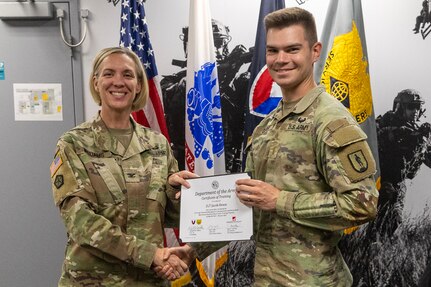 Col. Michelle M. Williams, U.S. Army Financial Management Command commander, presents 2nd Lt. Jacob Dease, National Guard Professional Education Center financial management training development support officer, with a certificate of completion for graduating the U.S. Army Operational Banking Short Course at the Maj. Gen. Emmett J. Bean Federal Center in Indianapolis June 6, 2025. USAFMCOM created the course to prepare more finance and comptroller officers and senior noncommissioned officers to serve as banking officers around the globe. (U.S. Army photo by Brad Staggs)