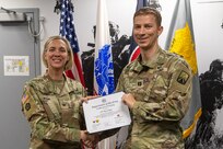 Col. Michelle M. Williams, U.S. Army Financial Management Command commander, presents Capt. Ryan Egan, 106th Finance Battalion disbursing officer, with a certificate of completion for graduating the U.S. Army Operational Banking Short Course at the Maj. Gen. Emmett J. Bean Federal Center in Indianapolis June 6, 2025. USAFMCOM created the course to prepare more finance and comptroller officers and senior noncommissioned officers to serve as banking officers around the globe. (U.S. Army photo by Brad Staggs)