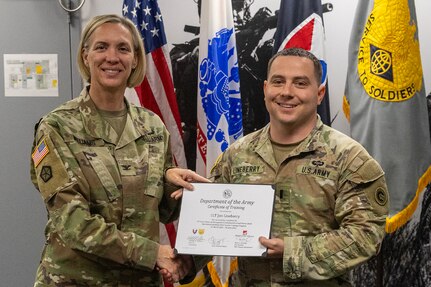 Col. Michelle M. Williams, U.S. Army Financial Management Command commander, presents 1st Lt. Jon Linebery, 12th Finance Operations Center operations officer, with a certificate of completion for graduating the U.S. Army Operational Banking Short Course at the Maj. Gen. Emmett J. Bean Federal Center in Indianapolis June 6, 2025. USAFMCOM created the course to prepare more finance and comptroller officers and senior noncommissioned officers to serve as banking officers around the globe. (U.S. Army photo by Brad Staggs)