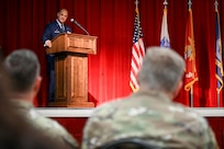 Man in uniform speaking at a podium on stage