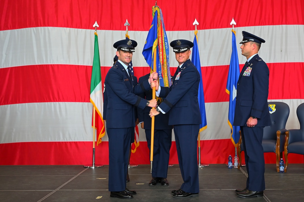 Brig. Gen. Tad Clark passing the guidon to to Maj. Gen. Paul Moga.