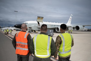 Two U.S. and an RAAF aircrew members observe an RC-135V/W Rivet Joint.