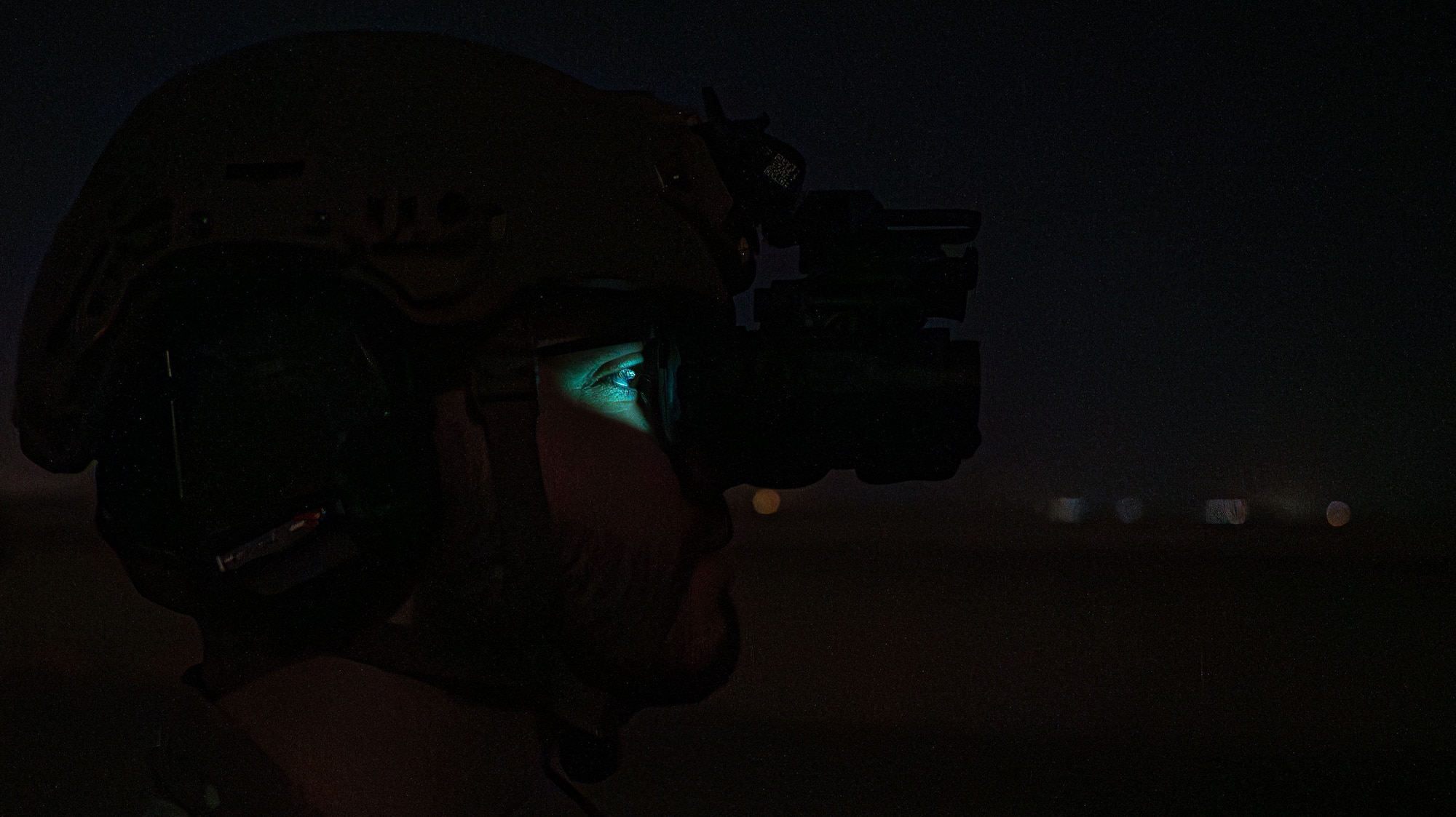 A silhouette of an Airman wearing night-vision goggles.