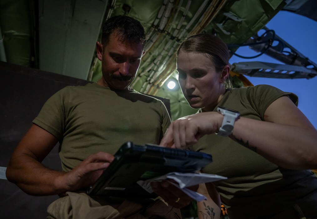 U.S. Air Force Master Sgt. Christopher Langus, left, 32nd Expeditionary Aerial Refueling Squadron chief boom operator, and Master Sgt. Elizabeth Canfield, 32nd EARS boom operator, reviews load plans within the U.S. Central Command area of responsibility, June 12, 2025. Boom operators primarily specialize in aerial refueling but also support cargo transport, passenger coordination and aeromedical evacuations when not actively refueling. (U.S. Air Force photo by Senior Airman Amanda Jett)
