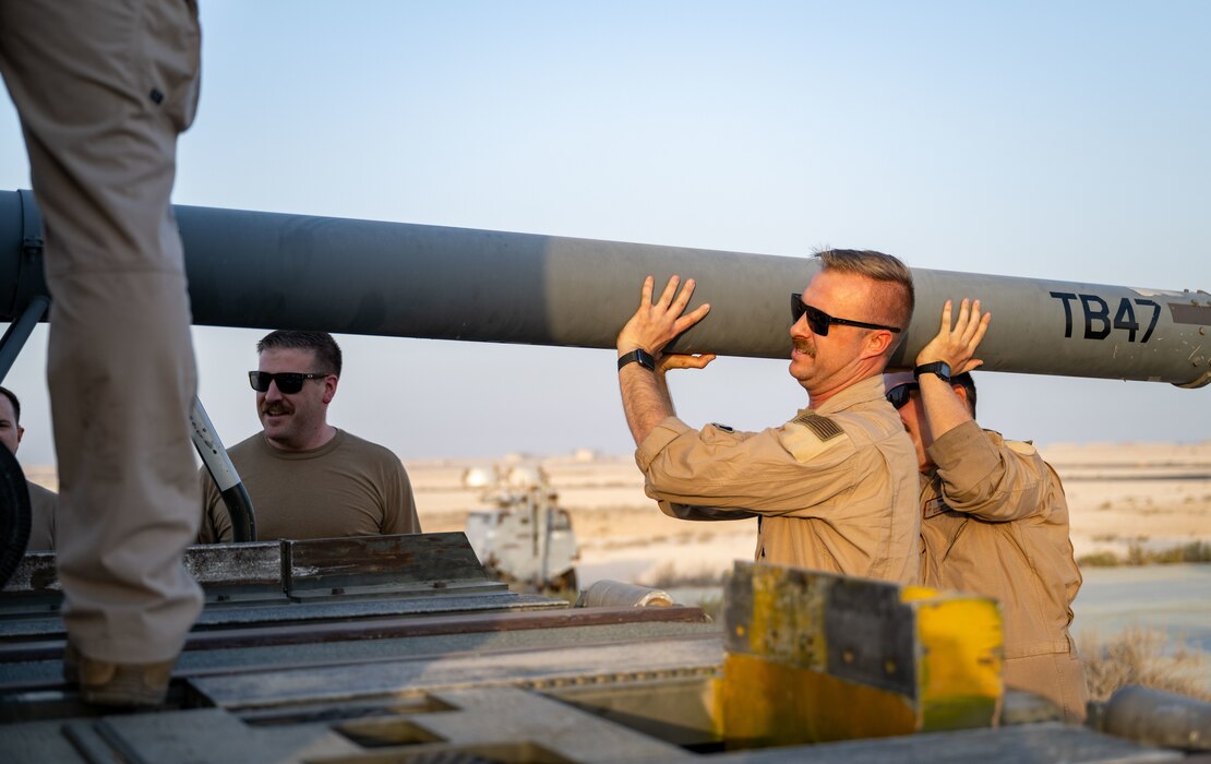 U.S. Airmen assigned to the 32nd Expeditionary Aerial Refueling Squadron lift gear onto a K-loader within the U.S. Central Command area of responsibility, June 12, 2025. The upload showcased how Mission-Ready Airmen employ expeditionary capabilities by performing tasks outside their primary Air Force Specialty Code. (U.S. Air Force photo by Senior Airman Amanda Jett)