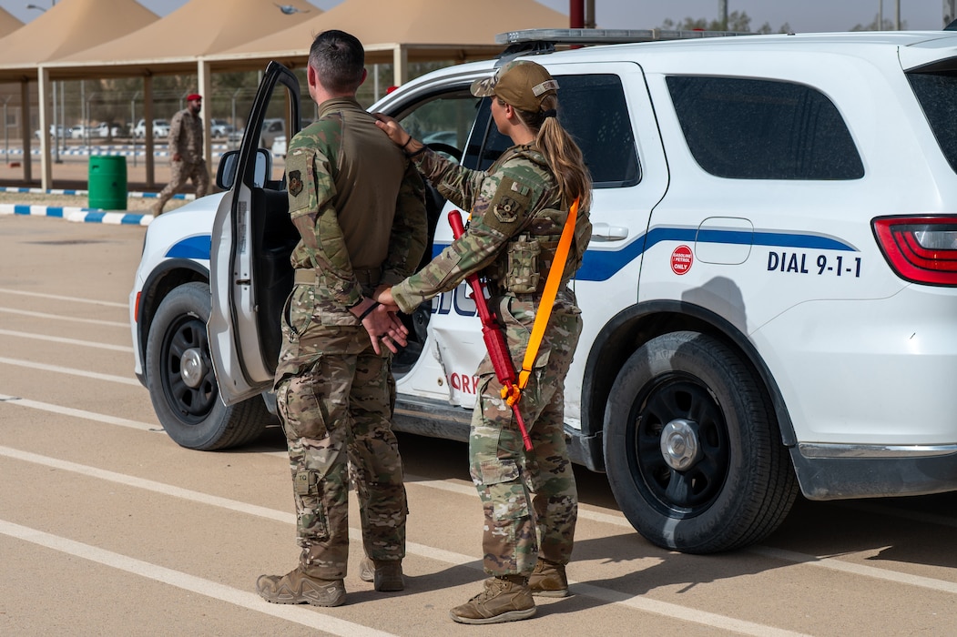 Two Airmen demonstrate handcuffing procedures during an exercsie