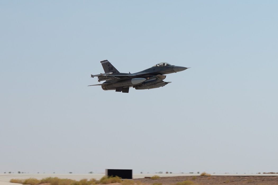 F-16 flies across blue sky