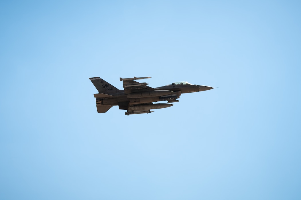 F-16 flies across blue sky