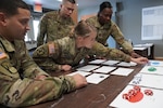 Representatives from the 469th Combat Support Sustainment Battalion overseeing administration for mobilizing Soldiers calculate unit throughput during the Level 1 Mobilization Tabletop Exercise, July 16-17, 2022, Fort McCoy, Wis.
