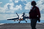 An F/A-18F Super Hornet from the "Fighting Redcocks" of Strike Fighter Squadron (VFA) 22 launches from the flight deck of the aircraft carrier USS Nimitz (CVN 68) in the Philippine Sea, April 22, 2025.