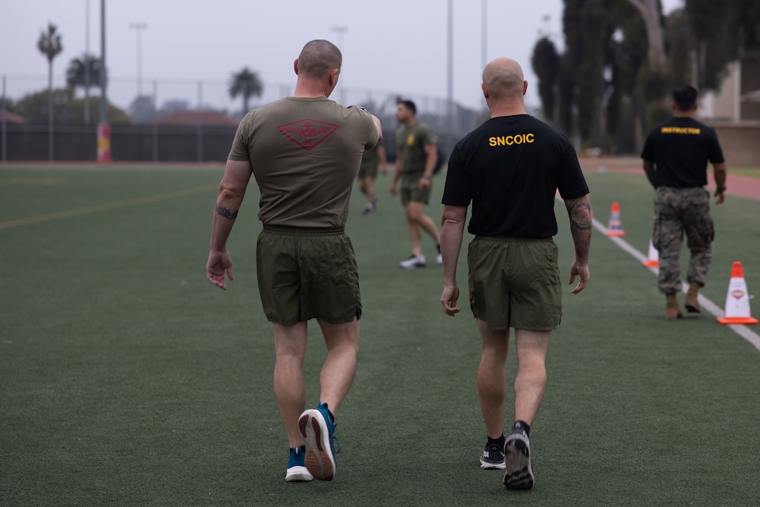 U.S. Marine Corps Sgt. Maj. James Horr, command senior enlisted leader of 3rd Marine Aircraft Wing and Gunnery Sgt. Dietrich Pate, the 3rd MAW Corporals Course senior noncommission officer in charge, walk the course before physical fitness training at Marine Corps Air Station Miramar, California, July 11, 2025.