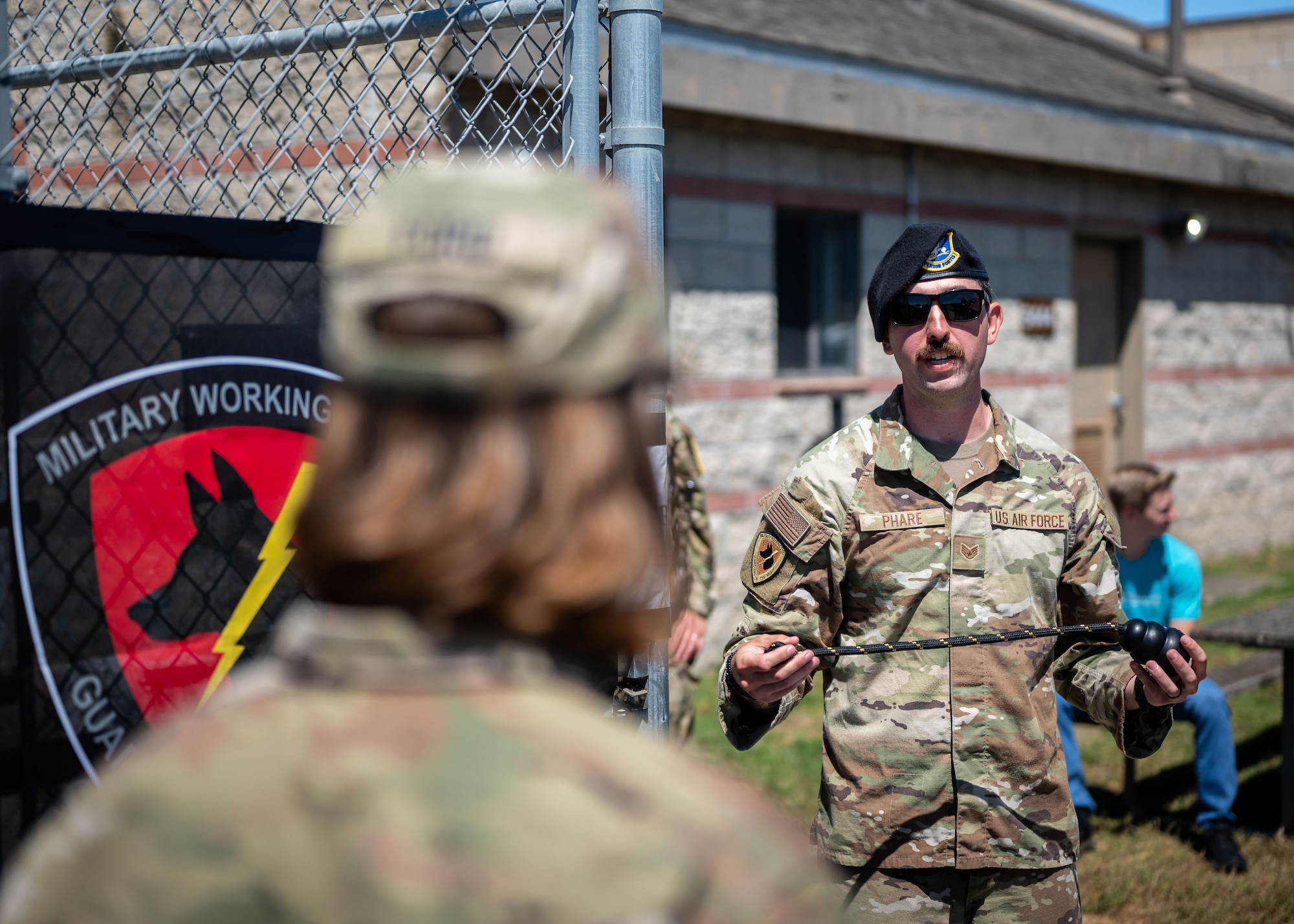 U.S. Air Force Staff Sgt. Zakary Phare, 30th Security Forces military working dog trainer, speaks to an attendee of a MWD demonstration at Vandenberg Space Force Base, Calif., July 11, 2025. Military working dog responsibilities include the detection and apprehension of assailants, narcotics, or explosives, along with patrolling the installation with their handlers.