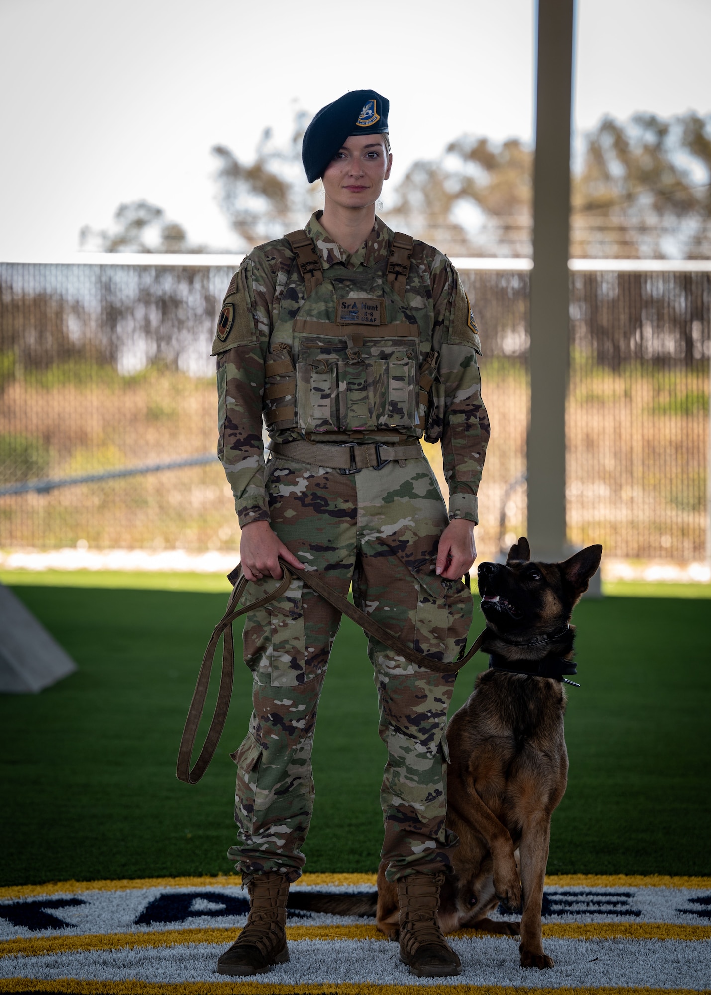 U.S. Air Force Senior Airman Cassidy Hunt, 30th Security Forces Squadron military working dog handler, and MWD Maugli, pose for a photo at Vandenberg Space Force Base, Calif., July 11, 2025. Military working dogs and their handlers work hand-in-paw to patrol, detect drugs and explosives, and perform specialized mission functions for the Department of Defense and other government agencies.