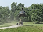 A UH-60M Black Hawk helicopter assigned to the New York National Guard's A Company, 3rd Battalion, 142nd Aviation, prepares to lift an M-117 howitzer belonging to the 1st Battalion, 258th Field Artillery during a training exercise at Fort Drum, New York on June 8, 2025. The 258th Field Artillery's C Battery will be part of a 246-Soldier New York Army National Guard contingent serving as the Opposing Force, or OPFOR, at the National Training Center from July 25 to August 3.