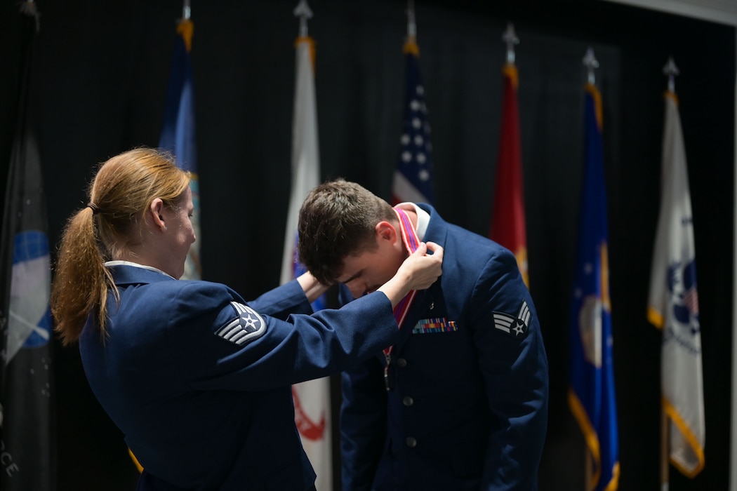 U.S. Air Force Senior Airman Noah Rogers, 17th Operational Medical Readiness Squadron student clinic medical technician, receives his medallion from Staff Sgt. Paula Bass, Goodfellow Airman Leadership School instructor, during the Airman Leadership School Class 25-E Graduation Ceremony at the Powell Event Center, Goodfellow Air Force Base, Texas, July 10, 2025. ALS equips Airmen with the skills to lead and manage in dynamic, complex and uncertain environments. (U.S. Air Force photo by Senior Airman Evelyn J. D’Errico)