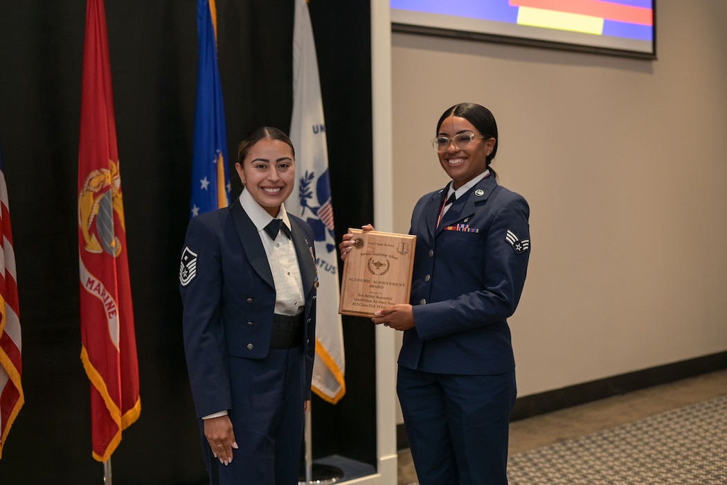 U.S. Air Force Master Sgt. Mary McCurdy, 17th Mission Support Group first sergeant, presents the Academic Achievement award to Senior Airman Ashley Beausoleil, 47th Healthcare Operations Squadron healthcare administrator, during the ALS Class 25-E graduation at the Powell Event Center, Goodfellow Air Force Base, Texas, July 10, 2025. The Academic Achievement Award is presented to the student with the highest overall average on all academic evaluations. (U.S. Air Force photo by Senior Airman Evelyn J. D’Errico)