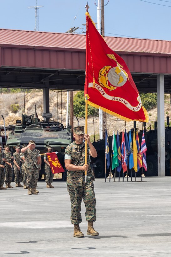 U.S. Marine Corps Sgt. Maj. Fausto H. Cabrera, the senior enlisted advisor of Assault Amphibian School, delivers the colors during a change of command ceremony at Marine Corps Base Camp Pendleton, California, July 10, 2025. During the ceremony, Col. Benjamin M. Venning relinquished command of AAS to Col. Lynn W. Berendsen. The change of command ceremony signifies a transition to new leadership and the continuation of the school’s constant preparedness to fight and win. (U.S. Marine Corps photo by Lance Cpl. Mhecaela J. Watts)