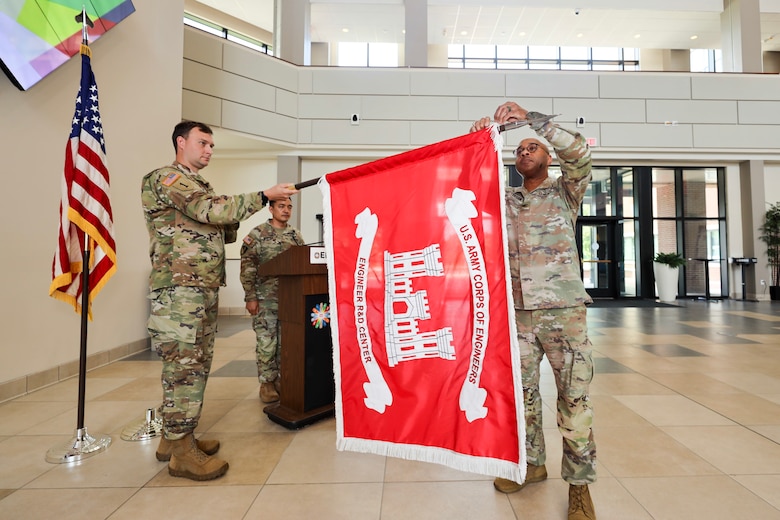 Outgoing ERDC Commander Col. Dr. Christian Patterson attaches the Army Superior Unit Award streamer to the USACE flag.