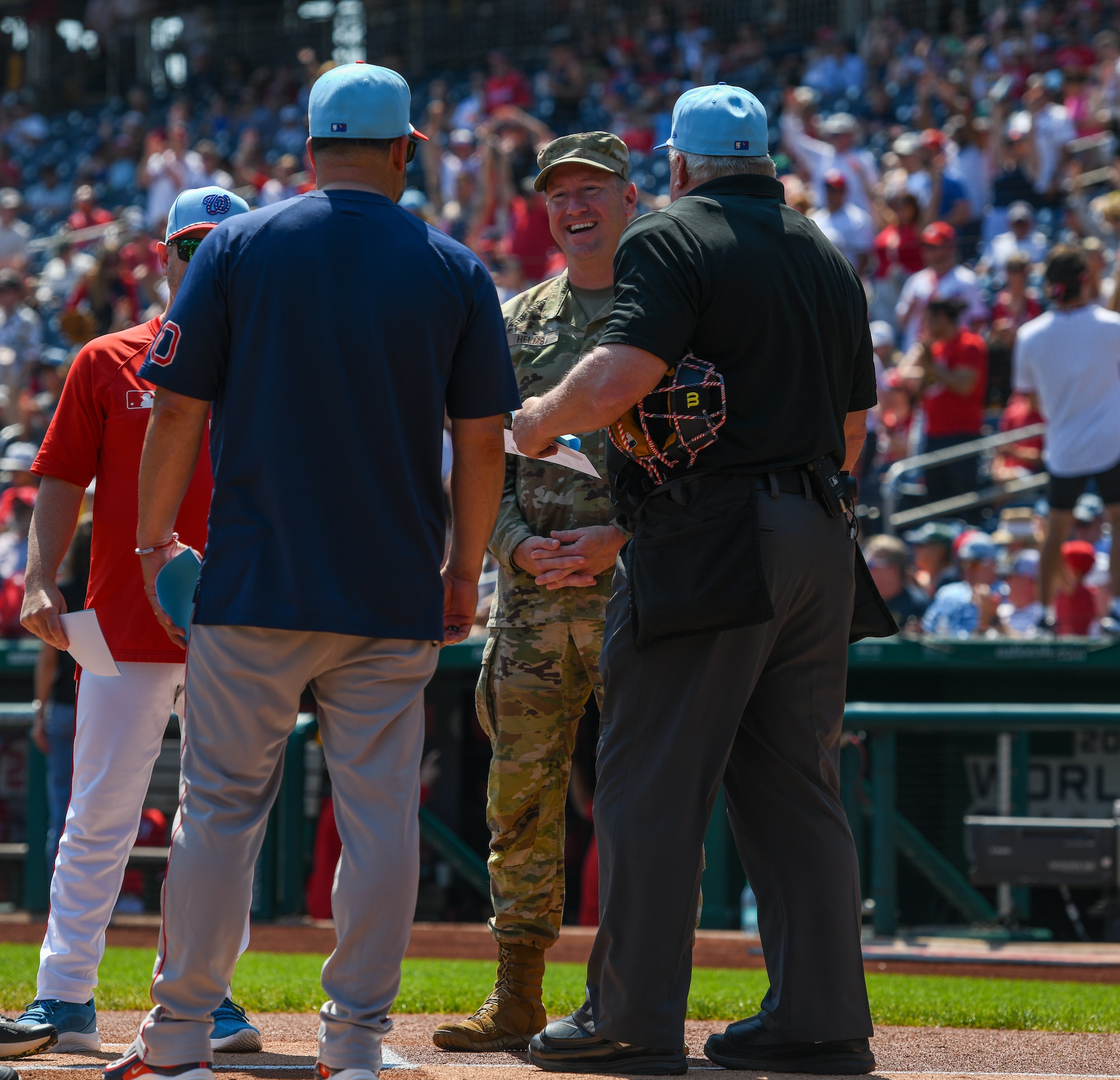 Umpires stand at the pitcher's mound.