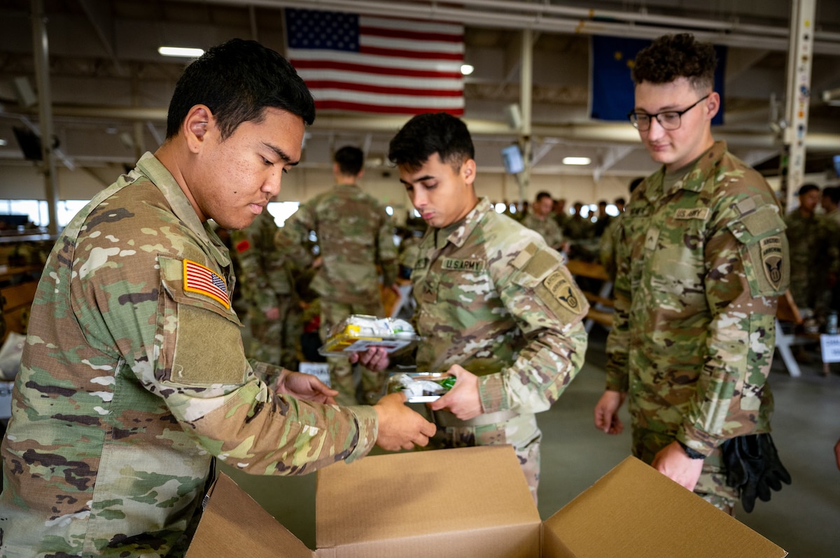 U.S. Army paratroopers assigned to the 3rd Battalion, 509th Parachute Infantry Regiment, 2nd Infantry Brigade Combat Team (Airborne), 11th Airborne Division receive food during a personnel deployment function line in support of Talisman Sabre at Joint Base Elmendorf-Richardson, Alaska, July 13, 2025.