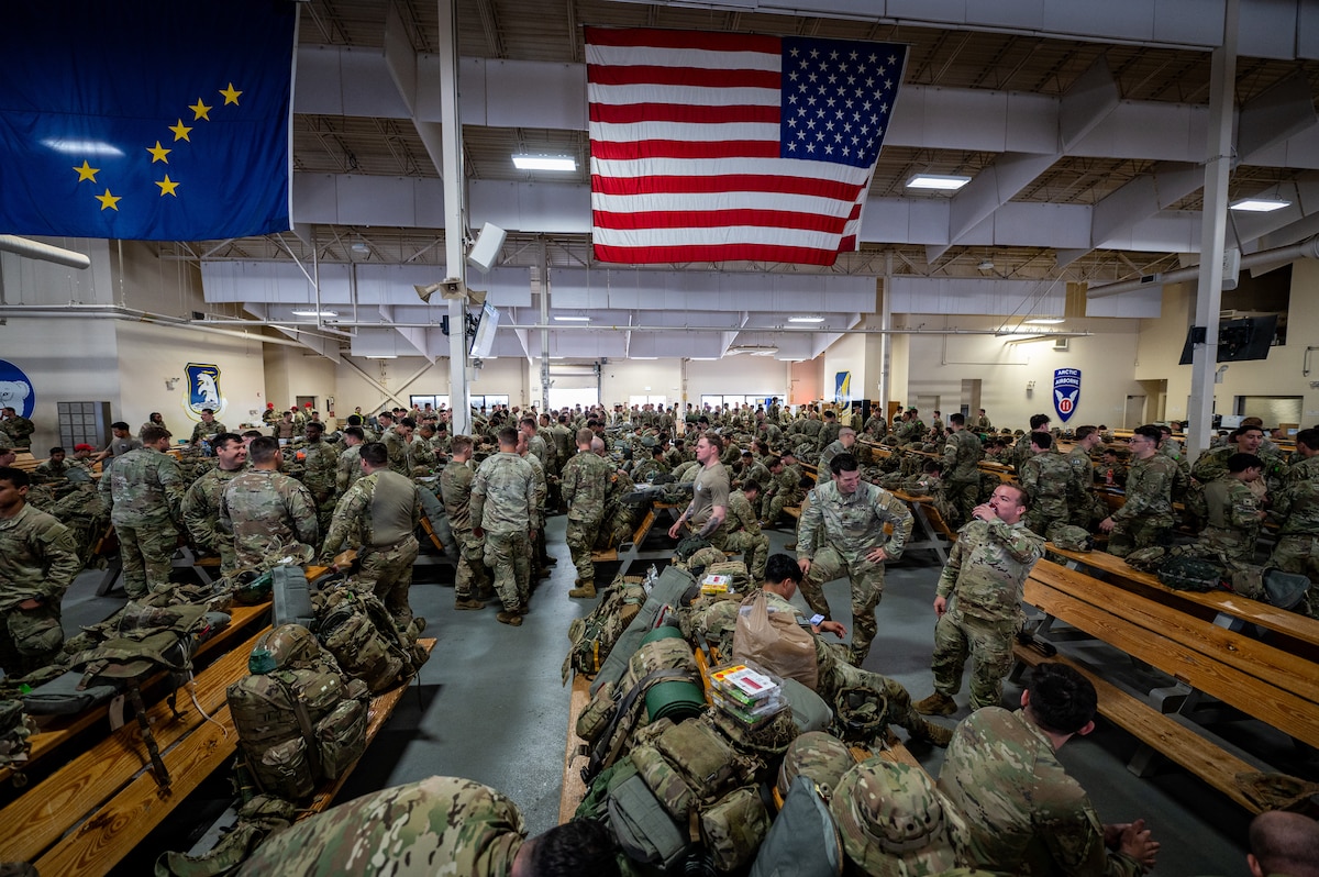 U.S. Army paratroopers assigned to the 3rd Battalion, 509th Parachute Infantry Regiment, 2nd Infantry Brigade Combat Team (Airborne), 11th Airborne Division gather at the Joint Mobility Complex during a personnel deployment function line in support of Talisman Sabre at Joint Base Elmendorf-Richardson, Alaska, July 13, 2025.