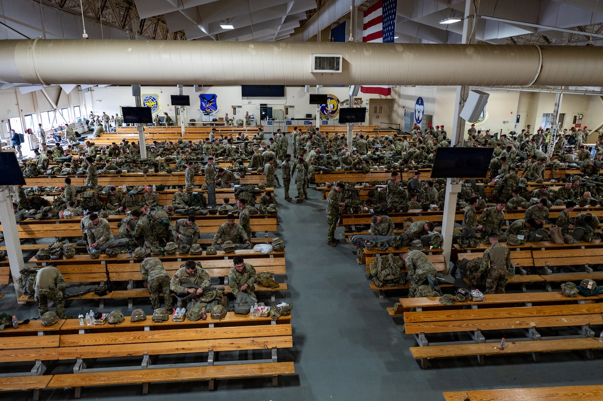 U.S. Army paratroopers assigned to the 3rd Battalion, 509th Parachute Infantry Regiment, 2nd Infantry Brigade Combat Team (Airborne), 11th Airborne Division gather at the Joint Mobility Complex during a personnel deployment function line in support of Talisman Sabre at Joint Base Elmendorf-Richardson, Alaska, July 13, 2025.