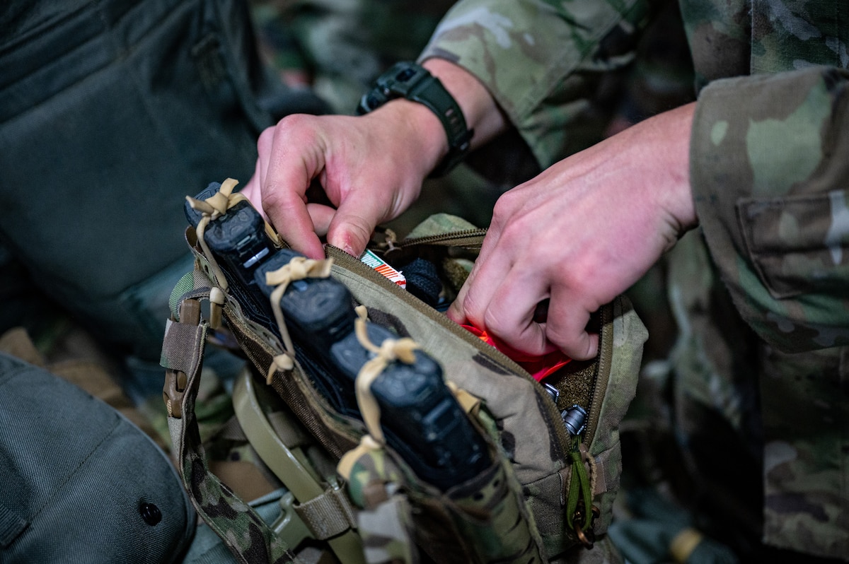 A U.S. Army paratrooper assigned to the 3rd Battalion, 509th Parachute Infantry Regiment, 2nd Infantry Brigade Combat Team (Airborne), 11th Airborne Division checks his gear at the Joint Mobility Complex during a personnel deployment function line in support of Talisman Sabre at Joint Base Elmendorf-Richardson, Alaska, July 13, 2025.