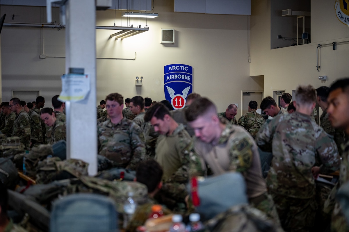 U.S. Army paratroopers assigned to the 3rd Battalion, 509th Parachute Infantry Regiment, 2nd Infantry Brigade Combat Team (Airborne), 11th Airborne Division move through a personnel deployment function line in support of Talisman Sabre at the Joint Mobility Complex on Joint Base Elmendorf-Richardson, Alaska, July 13, 2025.