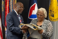 Gennaro Penn, U.S. Army Financial Management Command Military Pay Operations interim director, presents Wilhemenia Taylor, USAFMCOM MPO financial management analyst, with a token of appreciation during Taylor’s retirement ceremony at the Maj. Gen. Emmett J. Bean Federal Center in Indianapolis June 30, 2025. Taylor retired from USAFMCOM after more than 30 years of federal civil service and 15 years of military service. (U.S. Army photo by Mark R. W. Orders-Woempner)