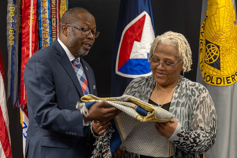 Gennaro Penn, U.S. Army Financial Management Command Military Pay Operations interim director, presents Wilhemenia Taylor, USAFMCOM MPO financial management analyst, with a token of appreciation during Taylor’s retirement ceremony at the Maj. Gen. Emmett J. Bean Federal Center in Indianapolis June 30, 2025. Taylor retired from USAFMCOM after more than 30 years of federal civil service and 15 years of military service. (U.S. Army photo by Mark R. W. Orders-Woempner)