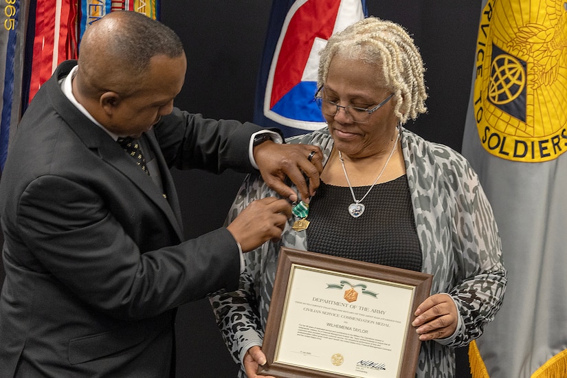 Ronald Houston, U.S. Army Financial Management Command Military Pay Operations Readiness East branch chief and senior financial manager, presents Wilhemenia Taylor, USAFMCOM MPO financial management analyst, with a Department of the Army Civilian Service Commendation Medal during Taylor’s retirement ceremony at the Maj. Gen. Emmett J. Bean Federal Center in Indianapolis June 30, 2025. Taylor retired from USAFMCOM after more than 30 years of federal civil service and 15 years of military service. (U.S. Army photo by Mark R. W. Orders-Woempner)