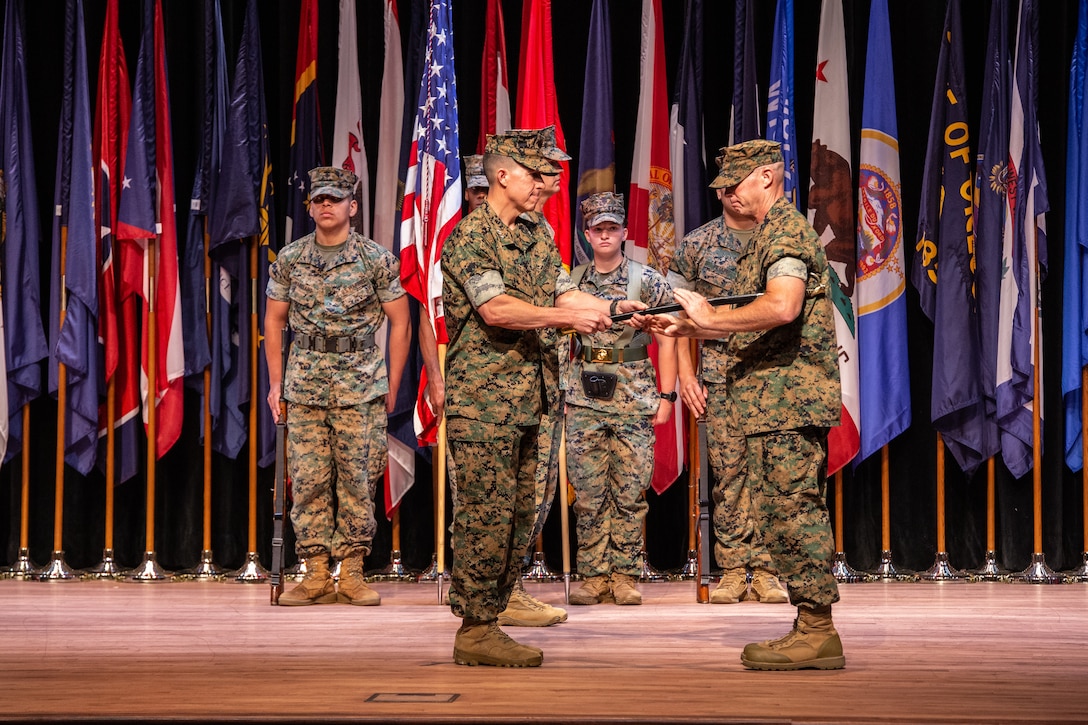 U.S. Marine Corps Lt. Gen. Benjamin T. Watson, the commanding general of Training and Education Command, left, passes the noncommissioned officer sword to Sgt. Maj. Ryan A. Gnecco, the incoming sergeant major of TECOM during a relief and appointment ceremony at Marine Corps University on Marine Corps Base Quantico, Virginia, July 1, 2025.During the ceremony, Sgt. Maj. Stephen A. Griffin relinquished his post as the TECOM sergeant major to Sgt. Maj. Ryan A. Gnecco. (U.S. Marine Corps photo by Cpl. Anthony C. Ramsey Jr.)